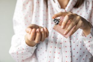 Perfume para o Dia das Mães. Mulher passando perfume.