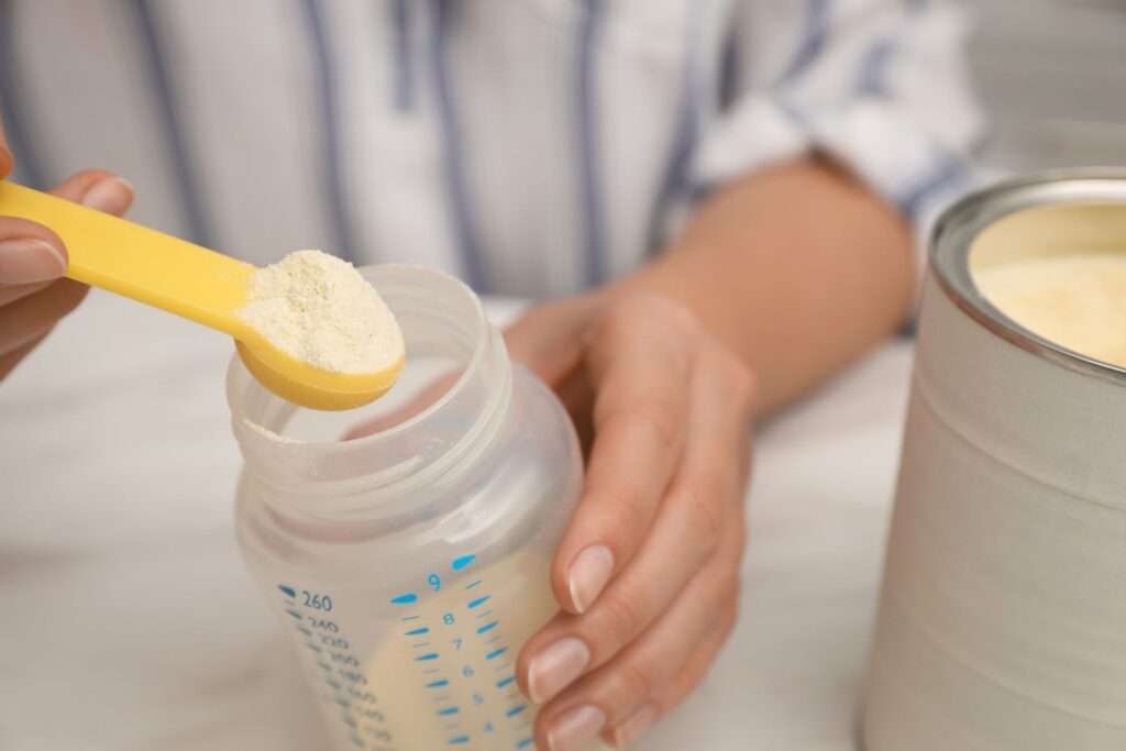 Fórmula infantil e composto lácteo. Pessoa preparando fórmula infantil.